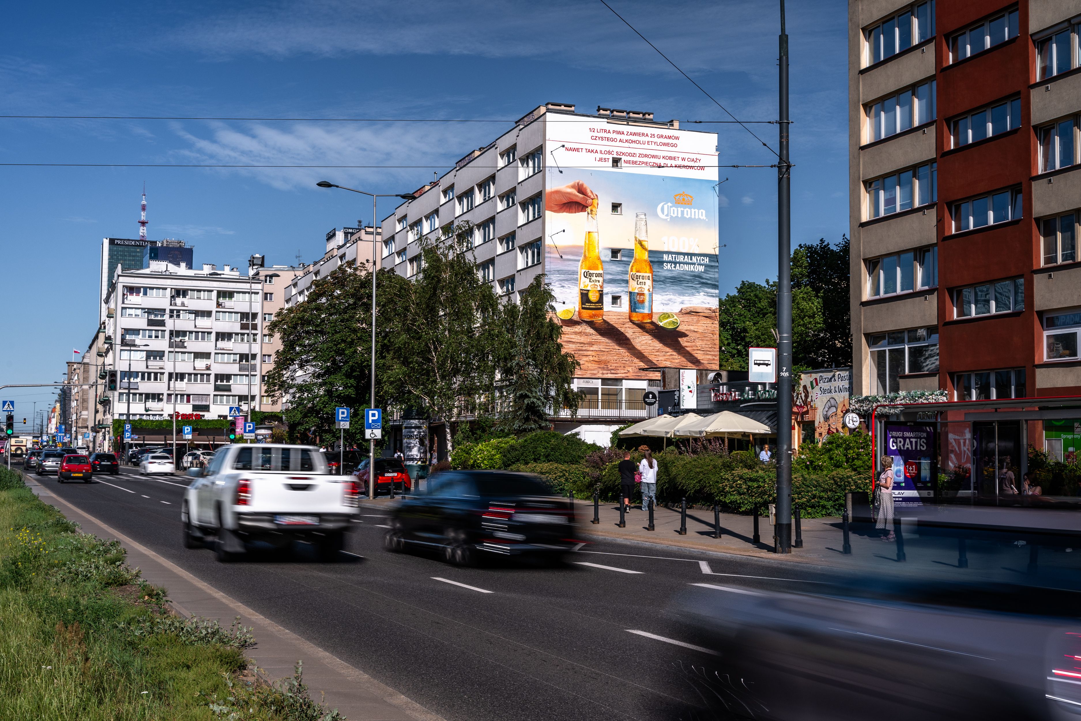 Malowany mural marki Corona przy Al. Jerozolimskich 117 w Warszawie, wykonany przez Good Looking Studio.