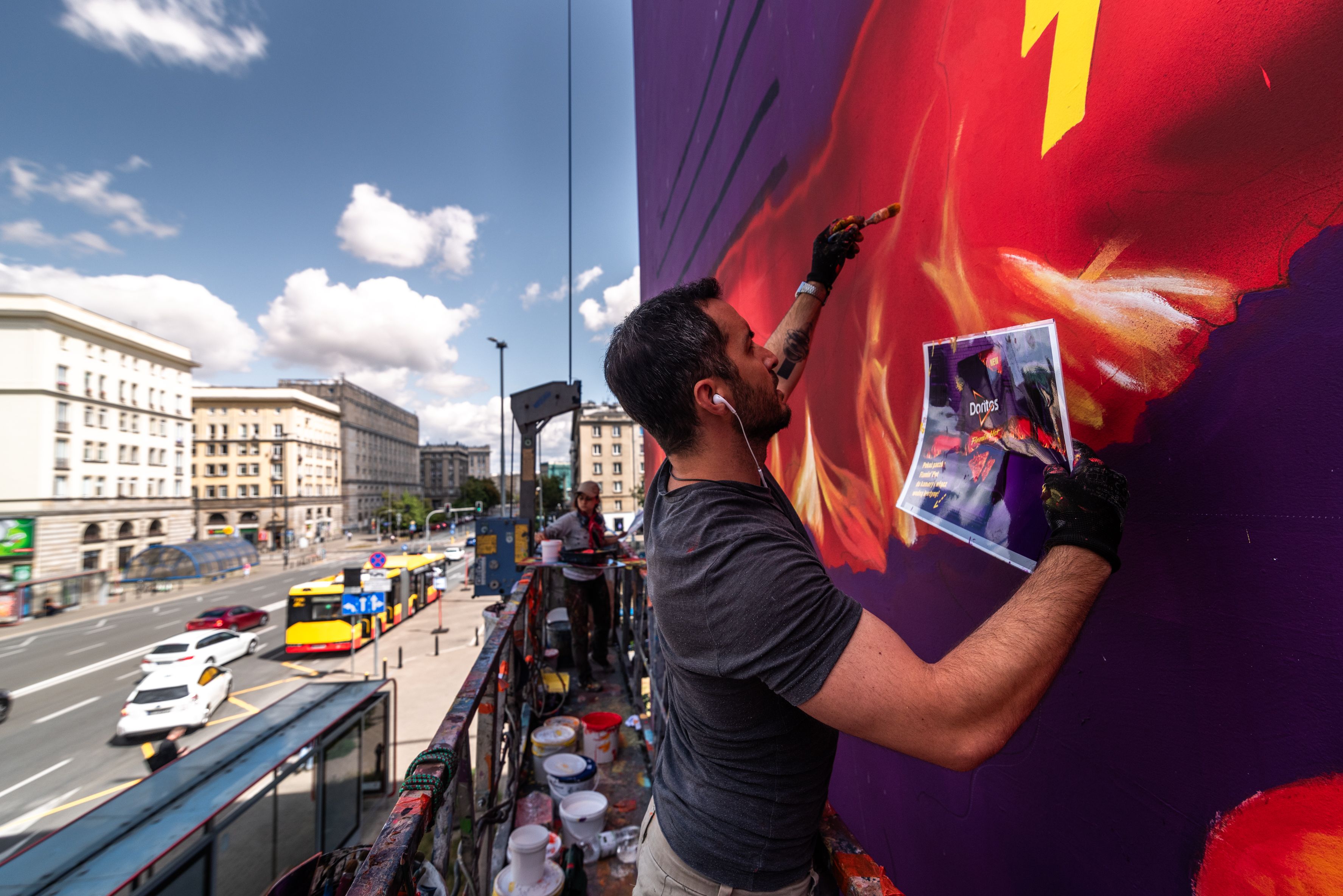 malarz maluje mural Flamin Hot w Warszawie