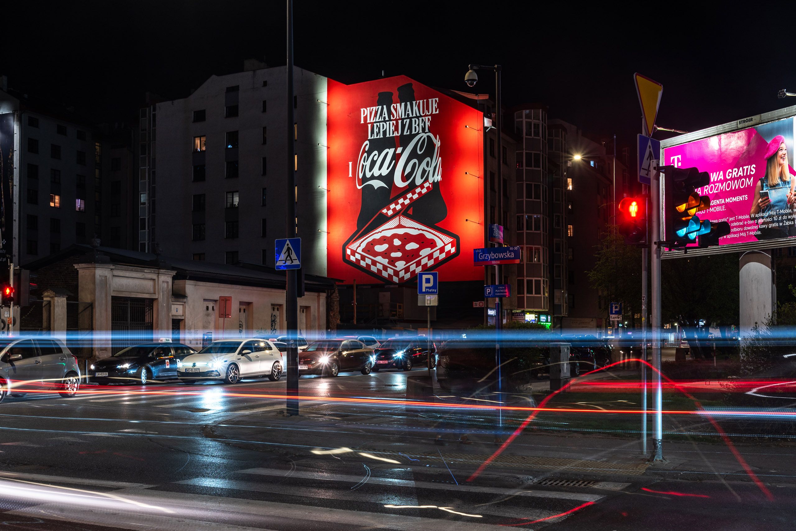 mural reklamowy wykonany dla marki Coca-Cola przedstawiający grafikę dwóch butelek coli z pizzą - na muralu widnieje napis pizza smakuje lepiej z bff oraz logo Coca-Cola