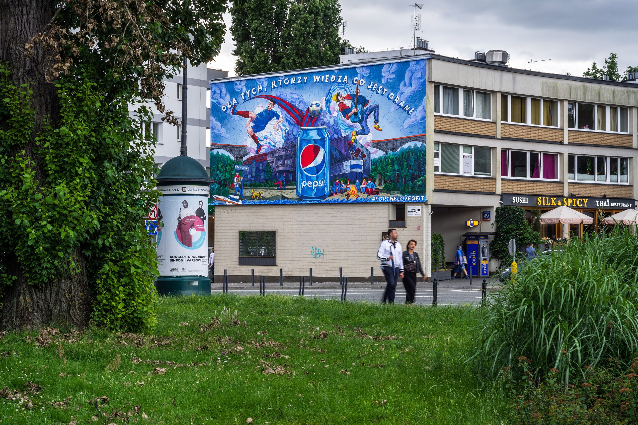 letnia sceneria muralu na Francuskiej namalowanego dla marki Pepsi przedstawiająca piłkarzy i muzyków na tle puszki Pepsi