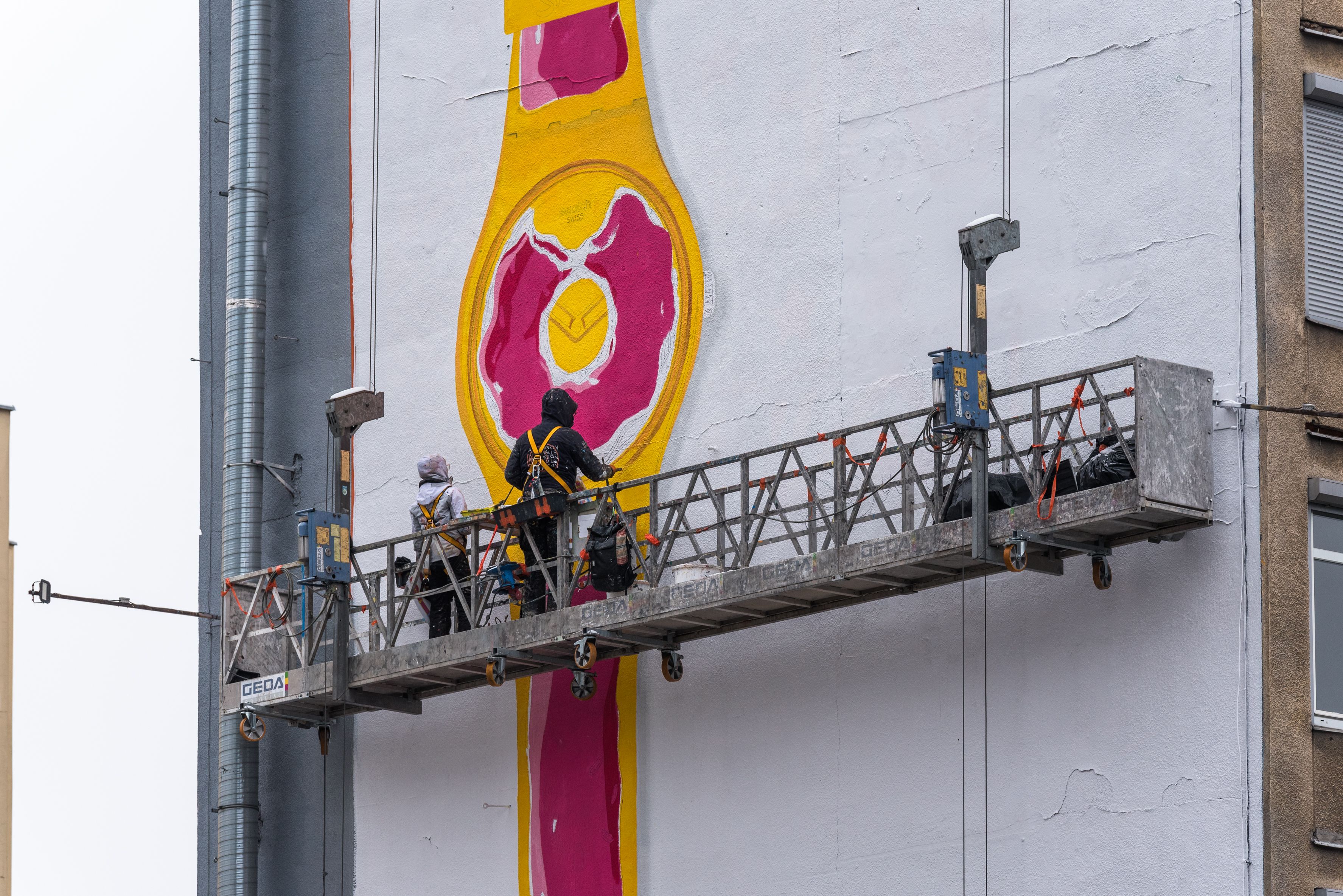 proces malowania muralu swatch, malarze na windzie