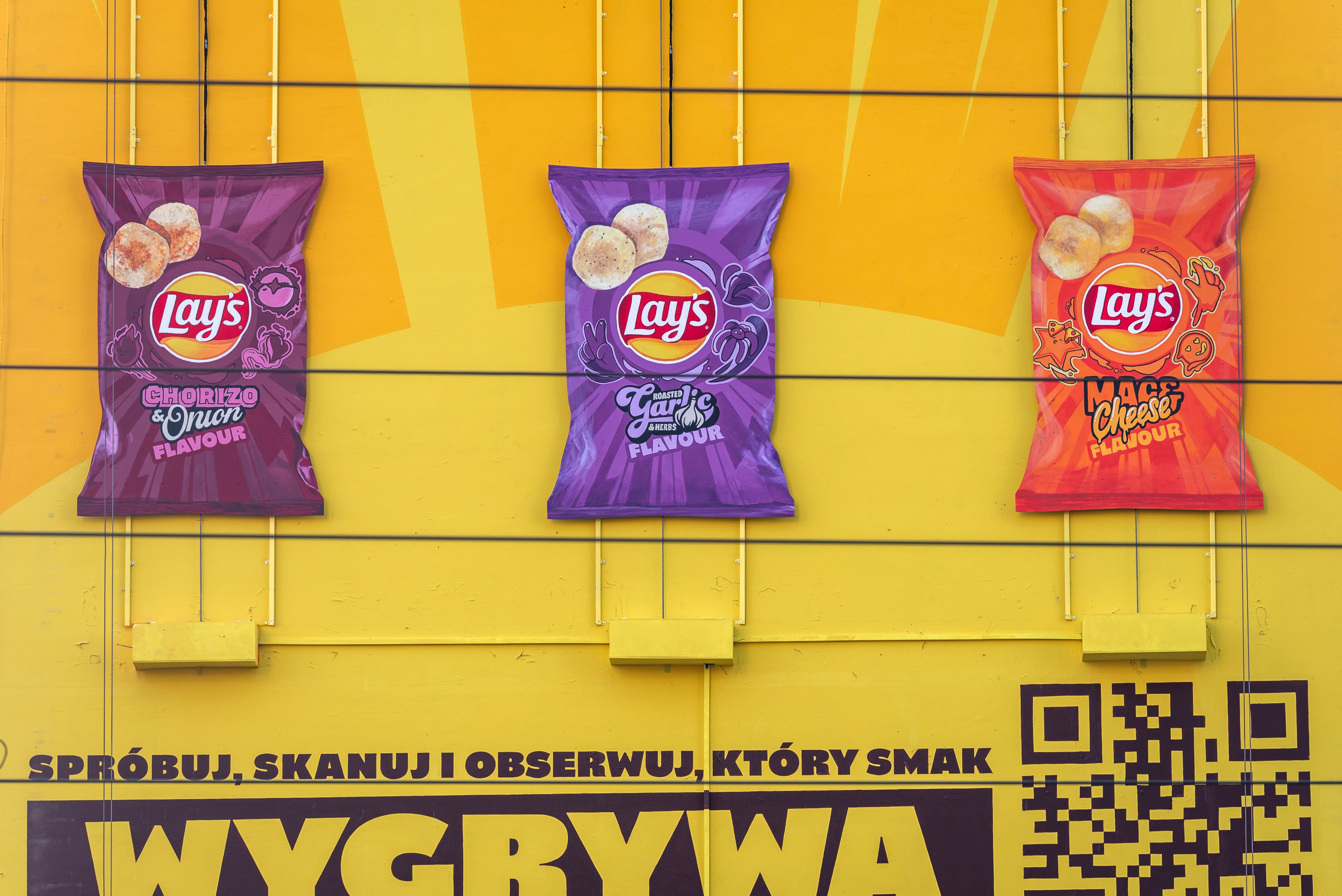 zbliżenie na paczki czipsów lays na muralu