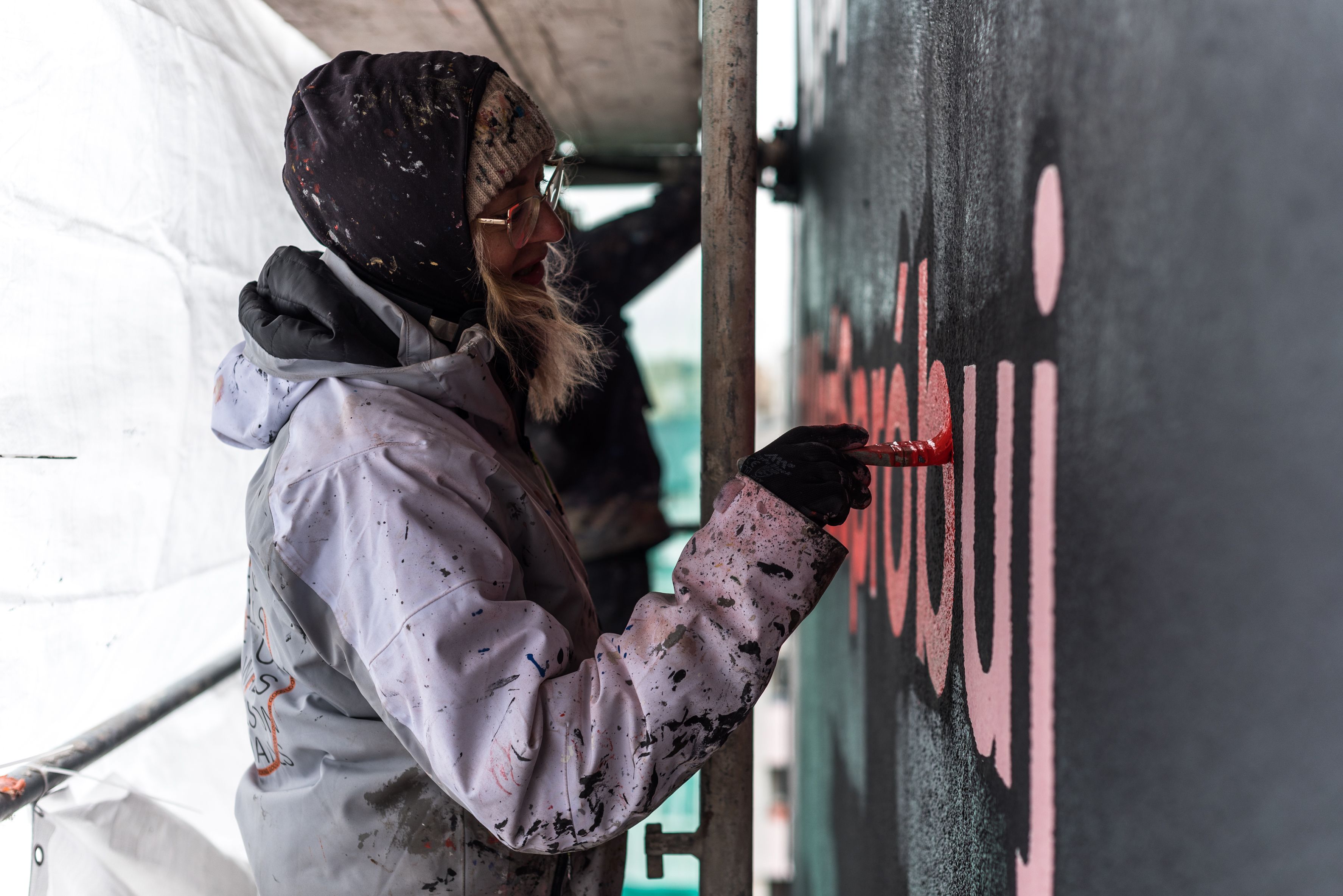 malarka maluje mural dla Coca-Coli w Warszawie