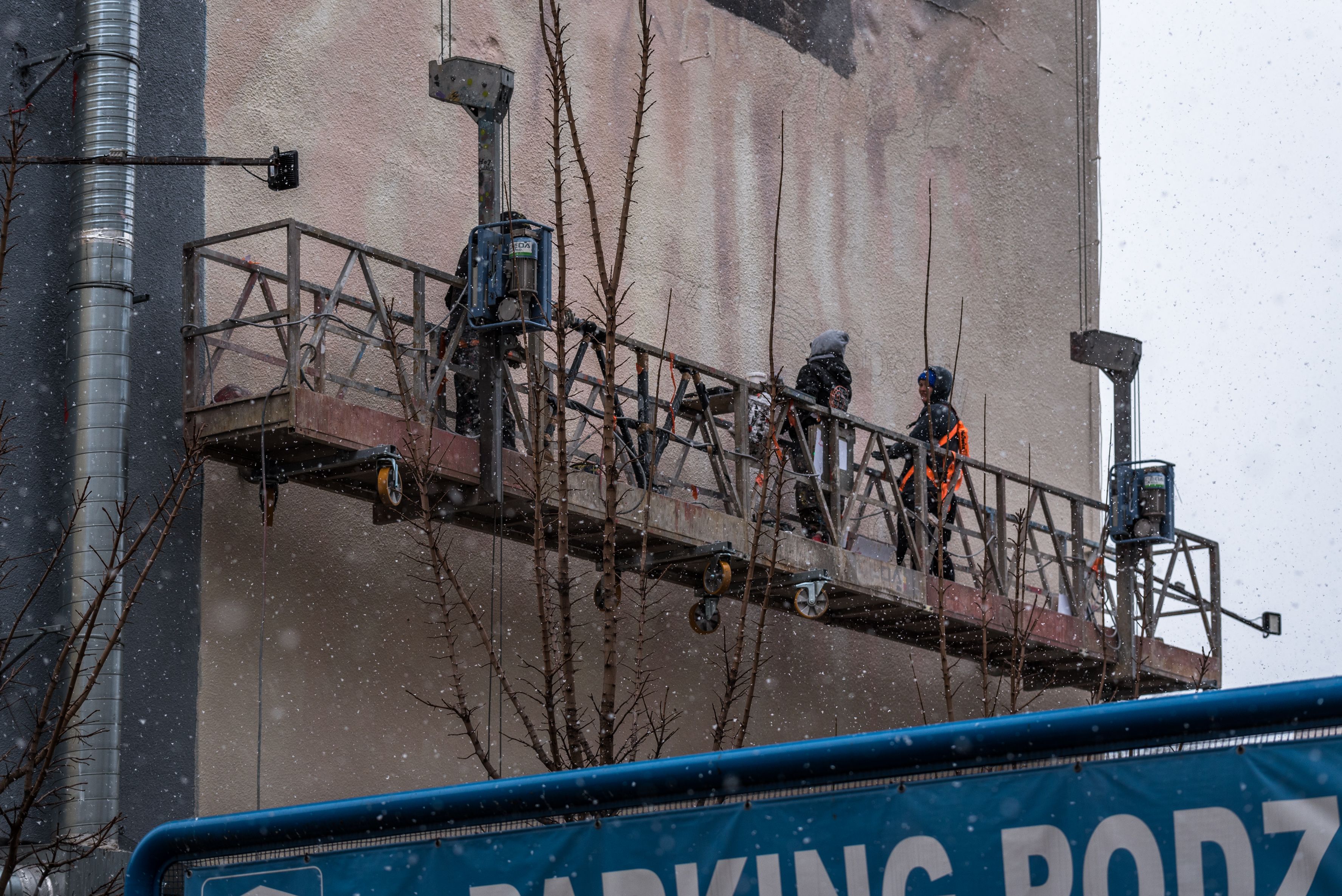 malarze na windzie malują mural dla Sony Music z portretem Malika Montany w Warszawie