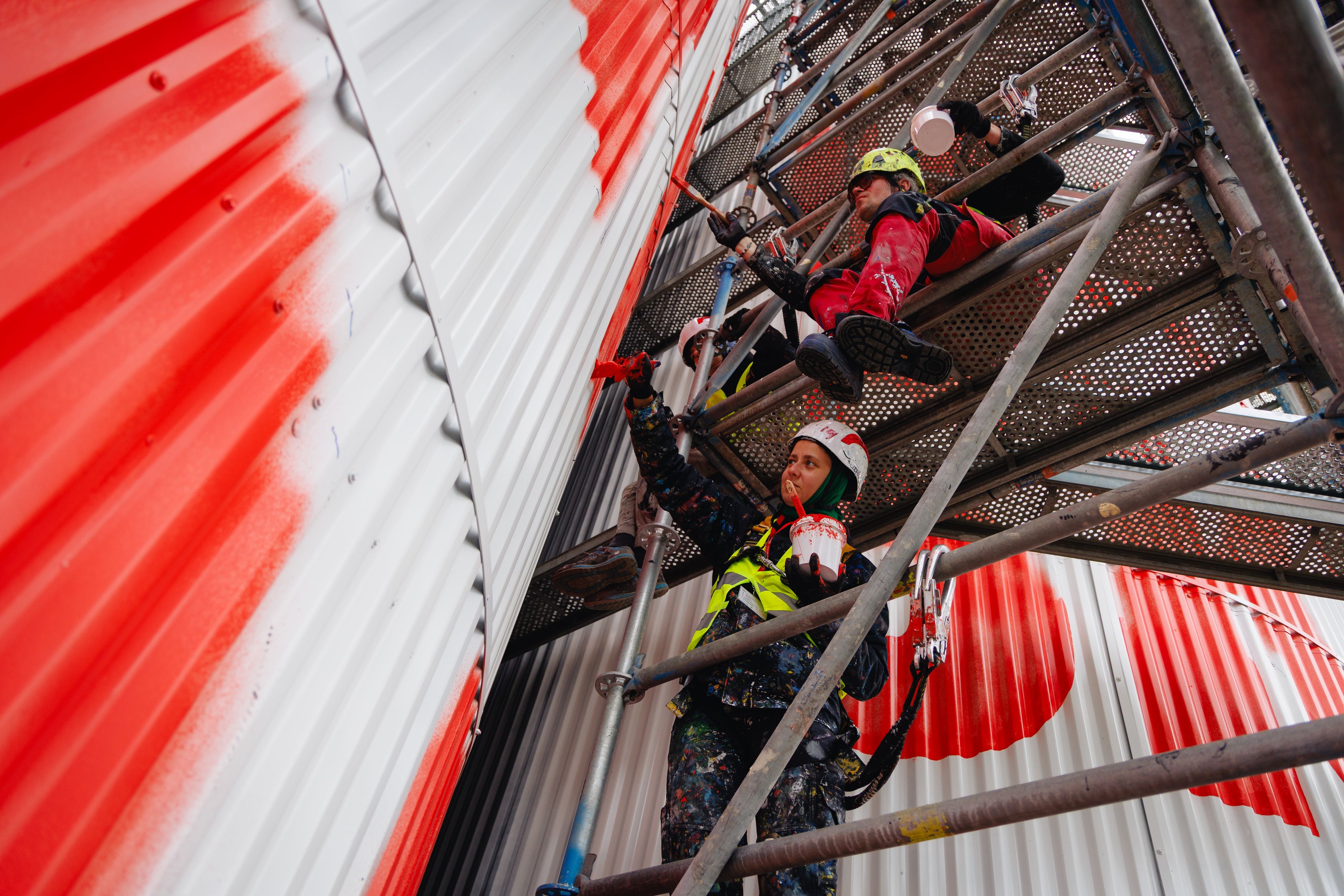 malarz na rusztowaniu maluje silos żywiec