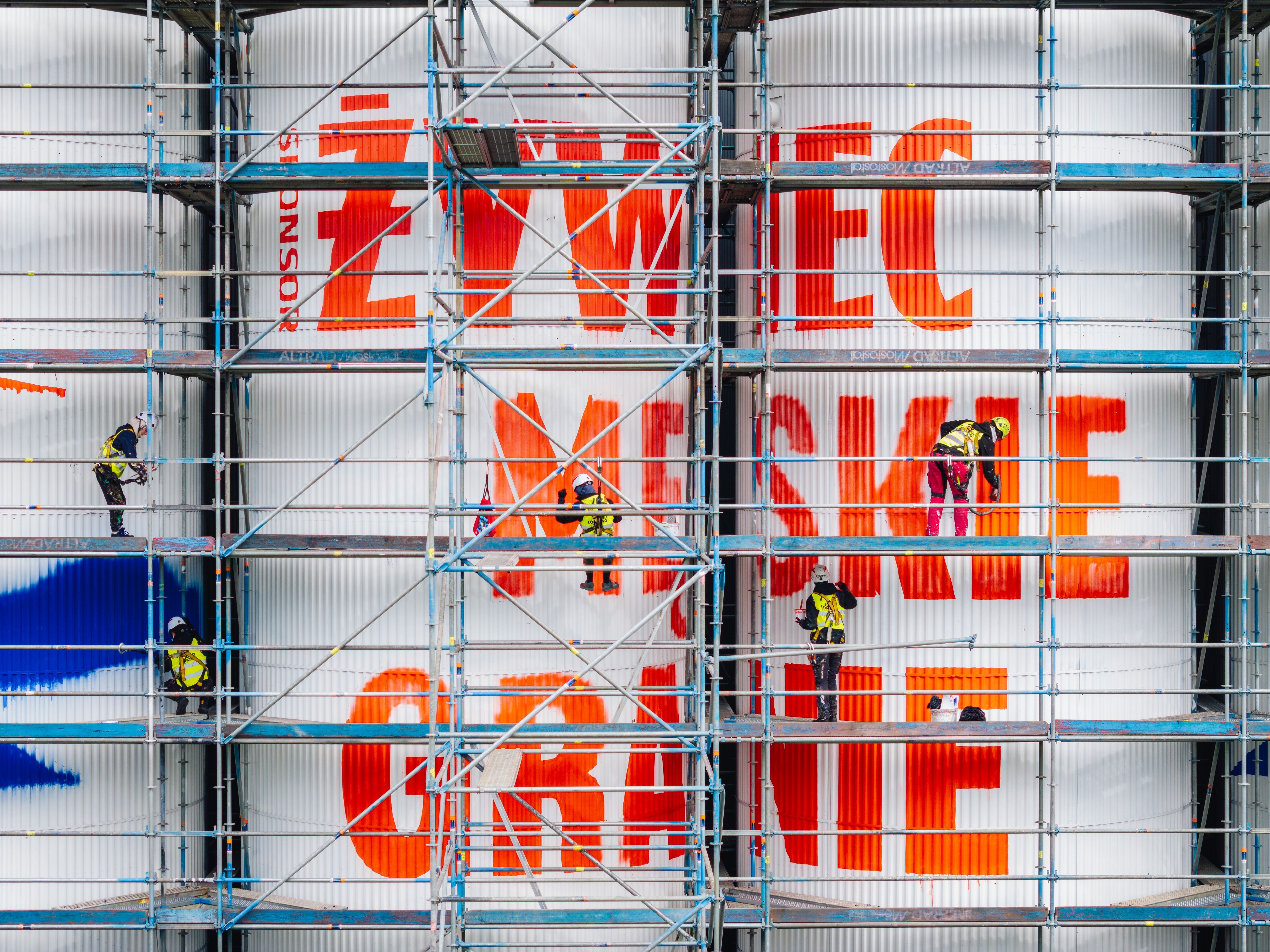malarze na rusztowaniu podczas malowania silosów w żywcu