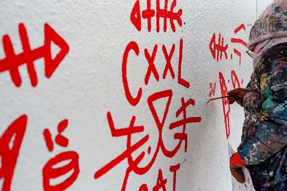 malarz maluje element murala 